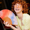 happy girl holding a colourful hand fan