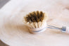 dish brush with hard and soft bristles on a wooden surface