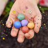 child's hand with colorful seed bombs 