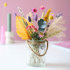 glass vase with a colorful bouquet of dried flowers. colors pink, light purple yellow