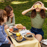 pic nic for three kids having fun, fruits and snacks on open and closed snack bags from fluf in front of them