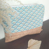 beach bag with cork and blue and brown geometrical patterned fabric on a dark brown surface with decorative leaves
