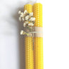 set of two beeswax sheet candle sticks tied together with thread and a beautiful dried little bunch of white flowers