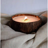 lit coconut candle on a natural color linen fabric