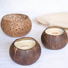 two coconut candle bowls and a coconut candle holder on a white clean surface