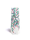 white paper vase with multicolored leaves on a white background