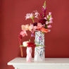 big and small paper vases full of fresh flowers on a white table