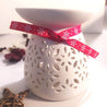 white ceramic melter with a red ribbon 